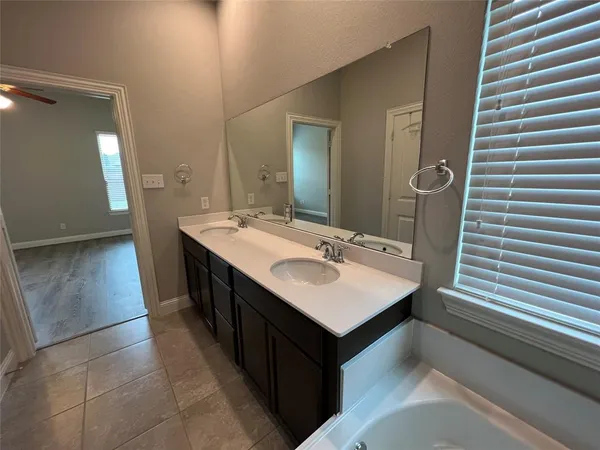 a en suite bathroom with a sink a mirror and a bathtub
