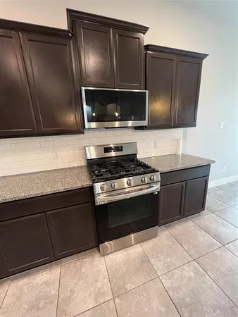 a kitchen with granite countertop a cabinets and steel appliances