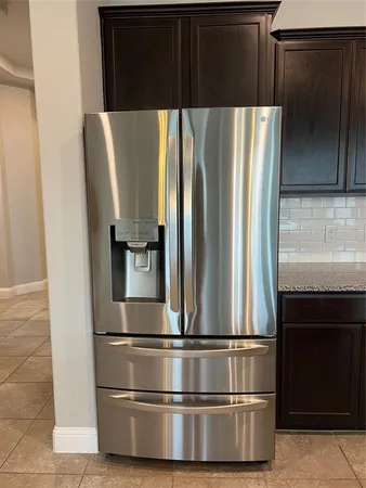 a metallic refrigerator freezer sitting in a kitchen