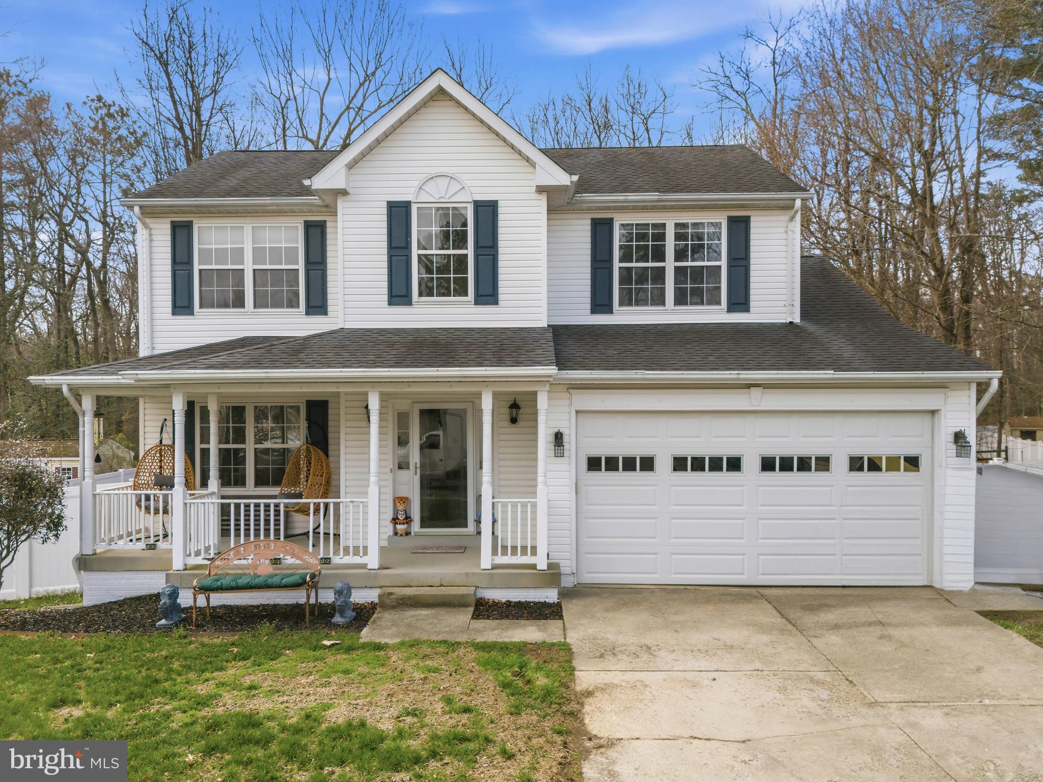 a view of a white house with a big yard and large trees