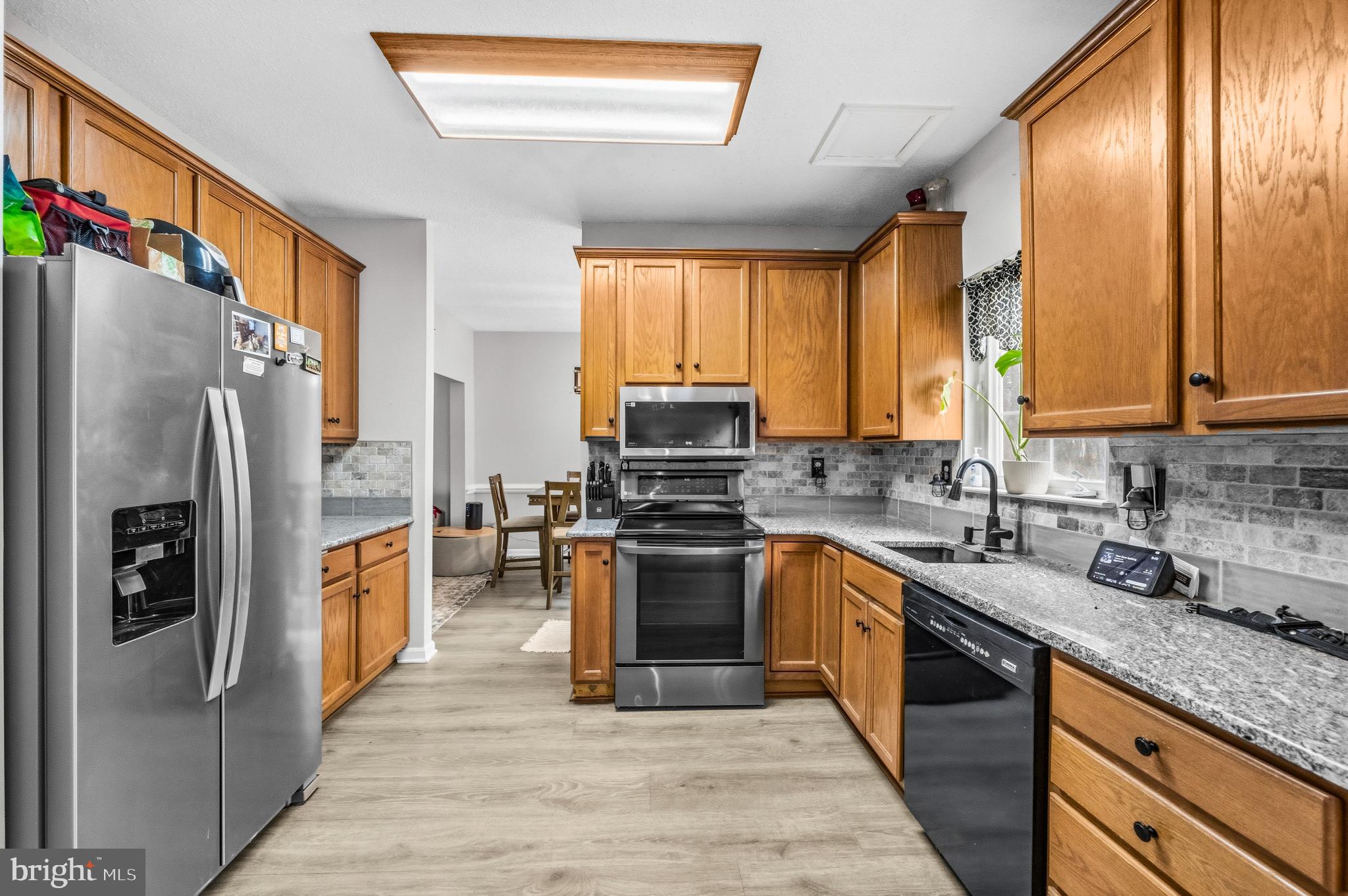 115 Myrtleleaf Circle La Plata, MD 20646 - Photo 11 of 37 a kitchen with stainless steel appliances granite countertop a refrigerator a sink dishwasher a stove and a dining table with wooden floor
