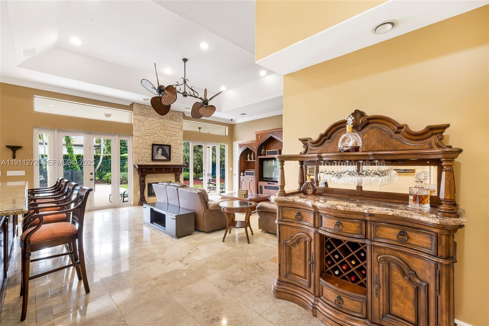 7250 Southwest 99th Street Pinecrest, FL 33156 - Photo 13 of 40 a living room with furniture a chandelier and a fireplace