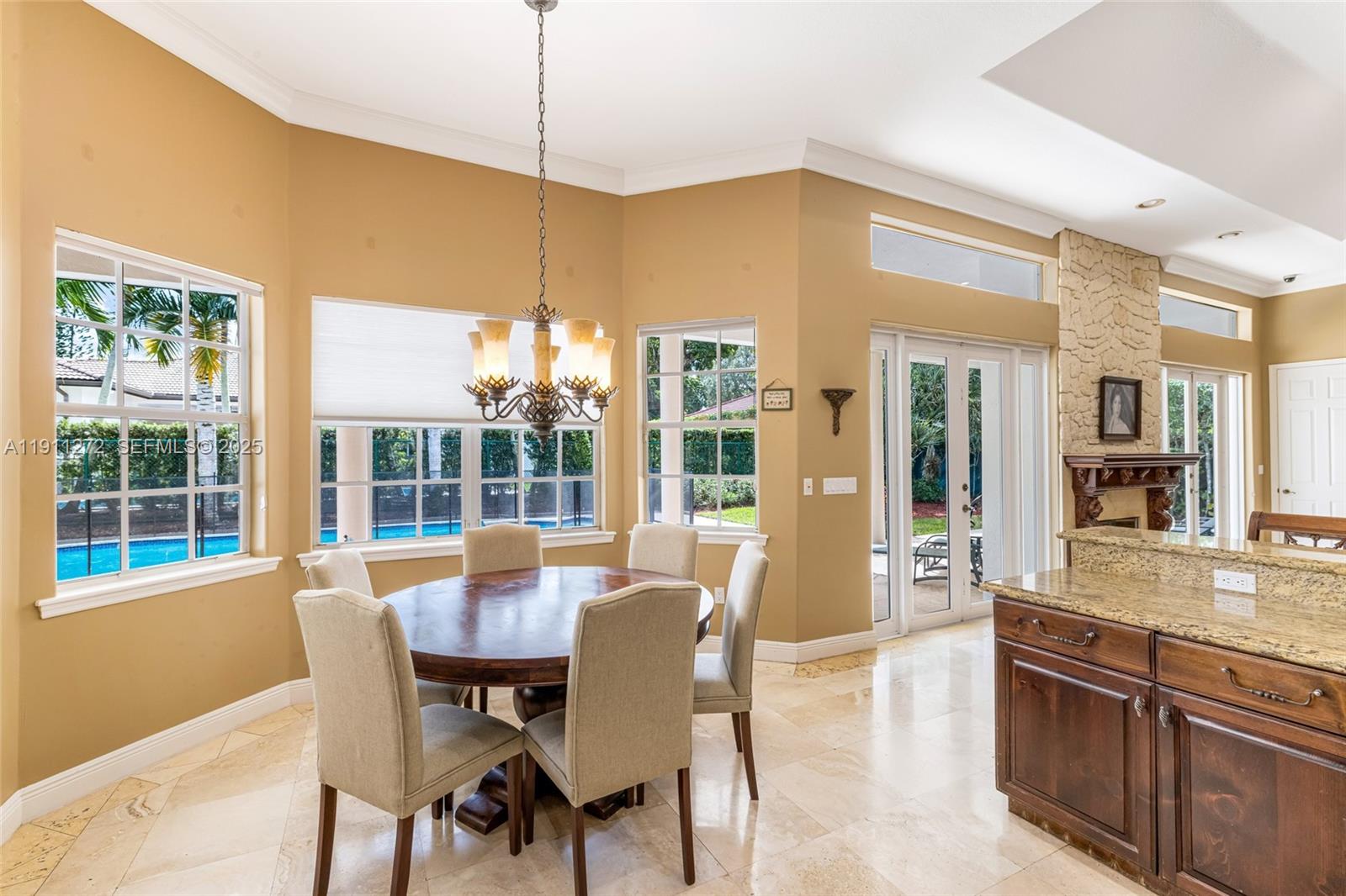 7250 Southwest 99th Street Pinecrest, FL 33156 - Photo 17 of 40 a dining room with furniture a chandelier and wooden floor