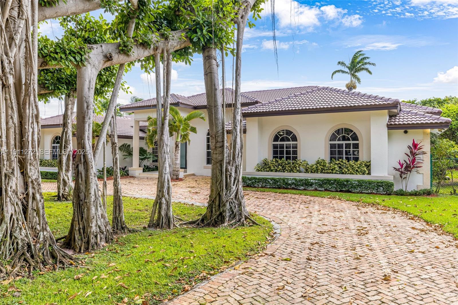 7250 Southwest 99th Street Pinecrest, FL 33156 - Photo 2 of 40 a front view of a house with garden