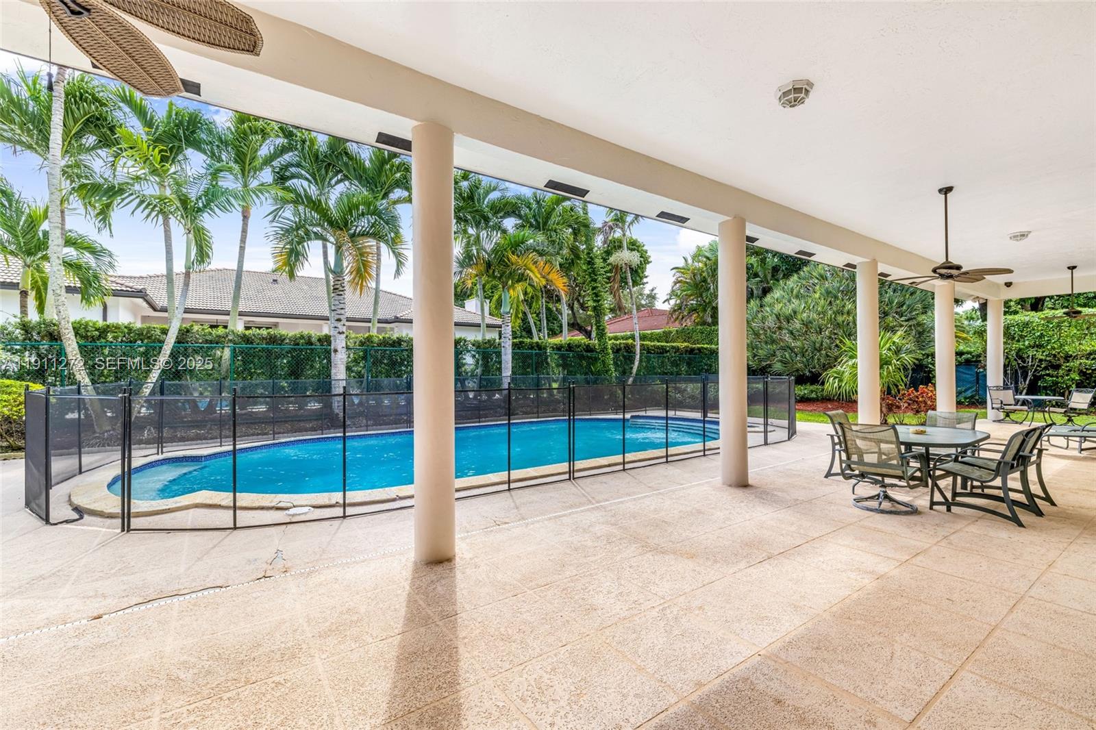 7250 Southwest 99th Street Pinecrest, FL 33156 - Photo 24 of 40 a view of swimming pool with a table and chairs in patio