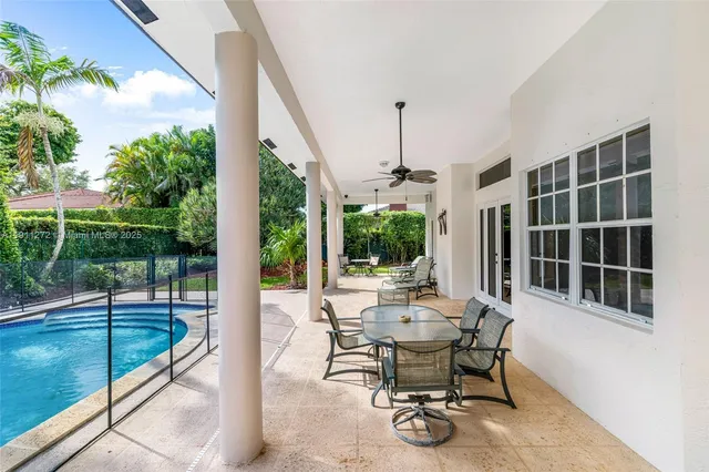 a view of a backyard with couches plants and large trees