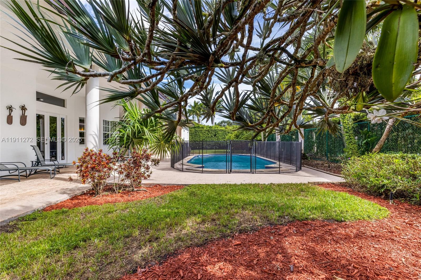 7250 Southwest 99th Street Pinecrest, FL 33156 - Photo 30 of 40 a view of a backyard with table and chairs and potted plants