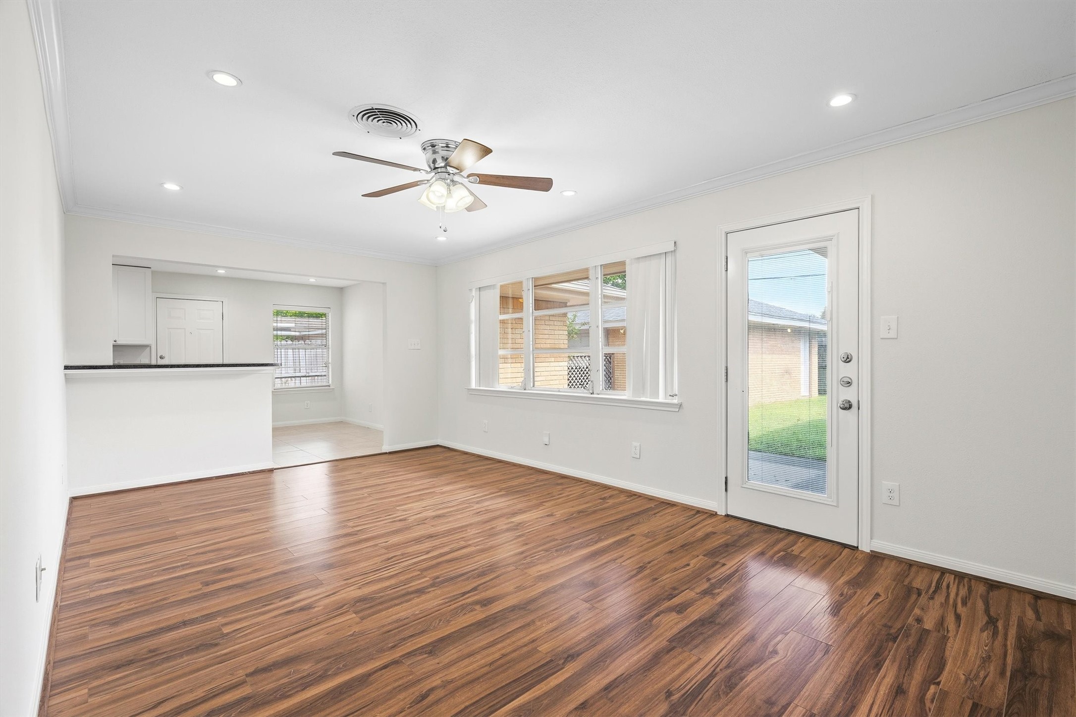 3331 Arbor Street Houston, TX 77004 - Photo 16 of 30 This living space opens to a kitchen area with a breakfast bar and has a door leading to a backyard, offering a seamless indoor-outdoor flow.