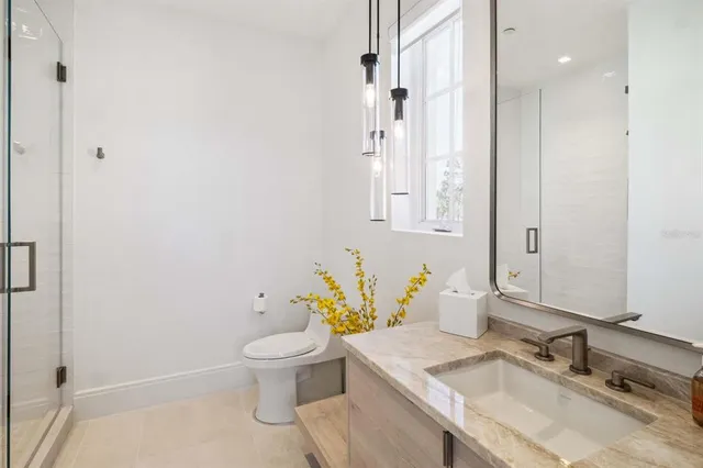 a bathroom with a granite countertop sink a toilet and a mirror