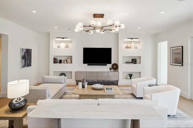 a living room with furniture a flat screen tv and kitchen view