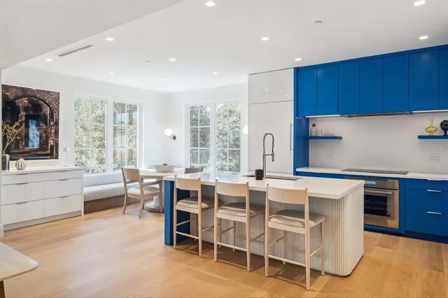 a large kitchen with cabinets table and chairs