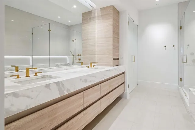 a bathroom with a double vanity sink a mirror and a shower