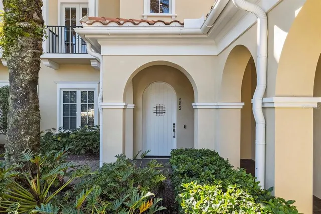 a view of a house with large windows and a flower garden