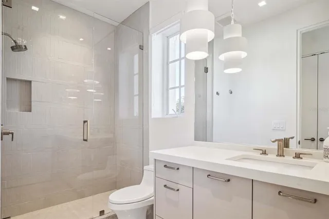 a bathroom with a granite countertop sink a toilet and shower