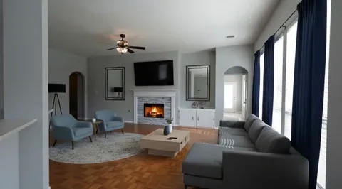 a living room with furniture a fireplace and a flat screen tv