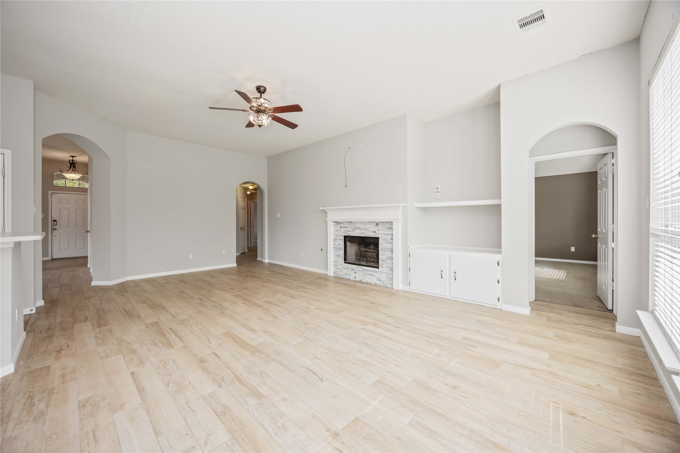 17102 Jetty Court Crosby, TX 77532 - Photo 12 of 39 Cozy fireplace with built-in shelving. The room has large windows for natural light and opens into adjacent rooms through elegant archways.
