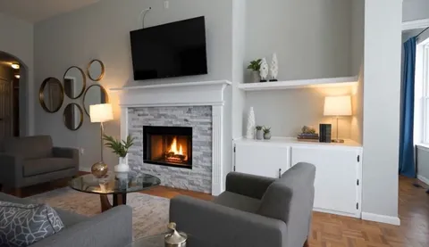 a living room with furniture a fireplace and a flat screen tv