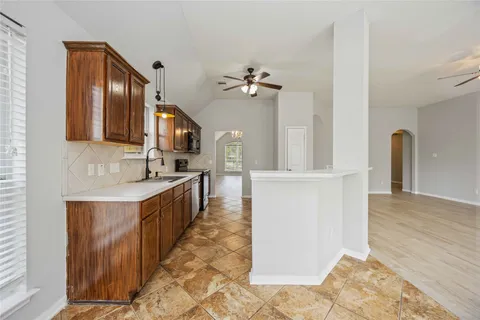 a large kitchen with stainless steel appliances kitchen island granite countertop a refrigerator a stove a sink and dishwasher with wooden floor