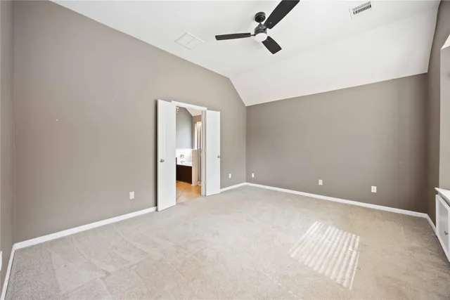 a view of an empty room with a chandelier fan