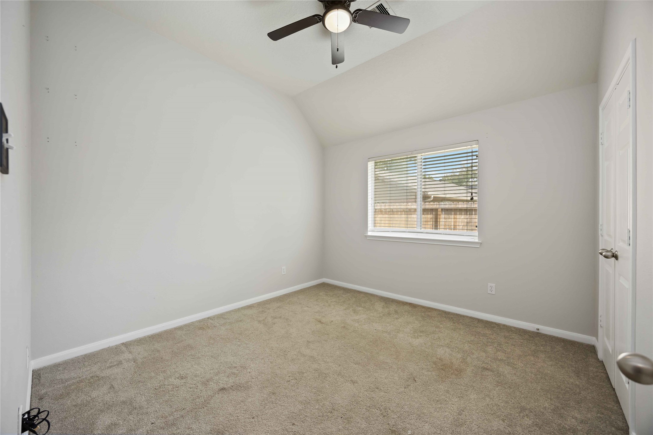 17102 Jetty Court Crosby, TX 77532 - Photo 28 of 39 2nd bedroom offers a ceiling fan and a window offering natural light and a view of the fenced backyard.