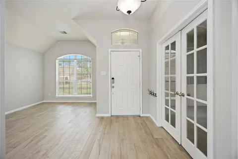 an empty room with wooden floor and windows