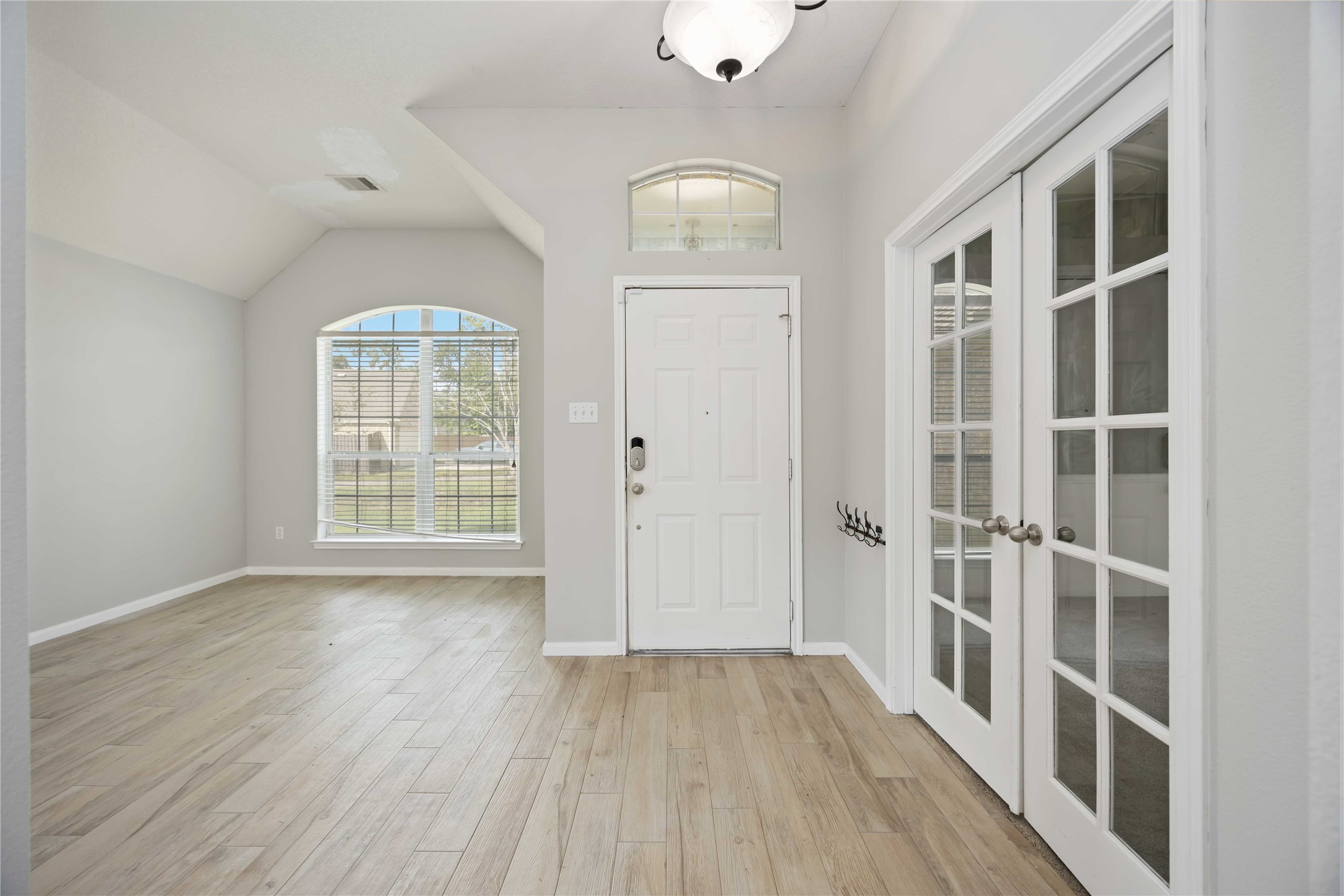 17102 Jetty Court Crosby, TX 77532 - Photo 3 of 39 Bright entryway with high ceilings. An arched window provides natural light, and neutral walls offer a fresh, airy feel.