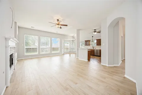a view of an empty room with a window and wooden floor