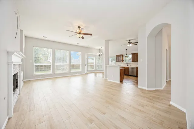 a large kitchen with stainless steel appliances kitchen island granite countertop a refrigerator a stove a sink and dishwasher with wooden floor