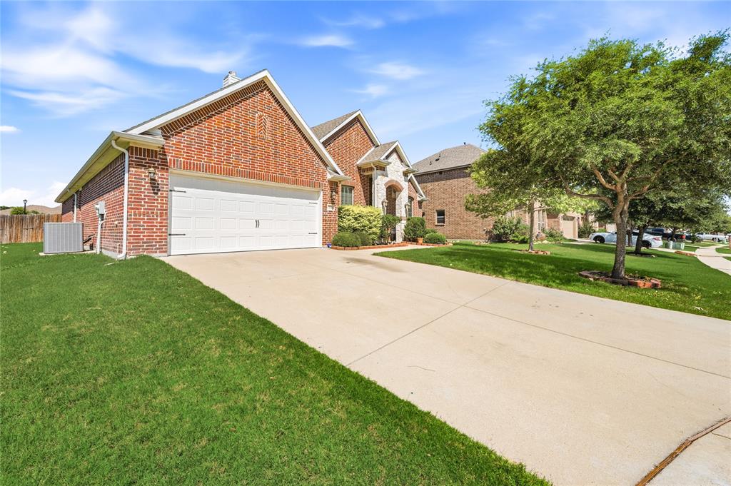 140 Chestnut Road Waxahachie, TX 75165 - Photo 2 of 26 Brick exterior with stone accents, featuring a two-car garage, concrete driveway, and established front landscaping
