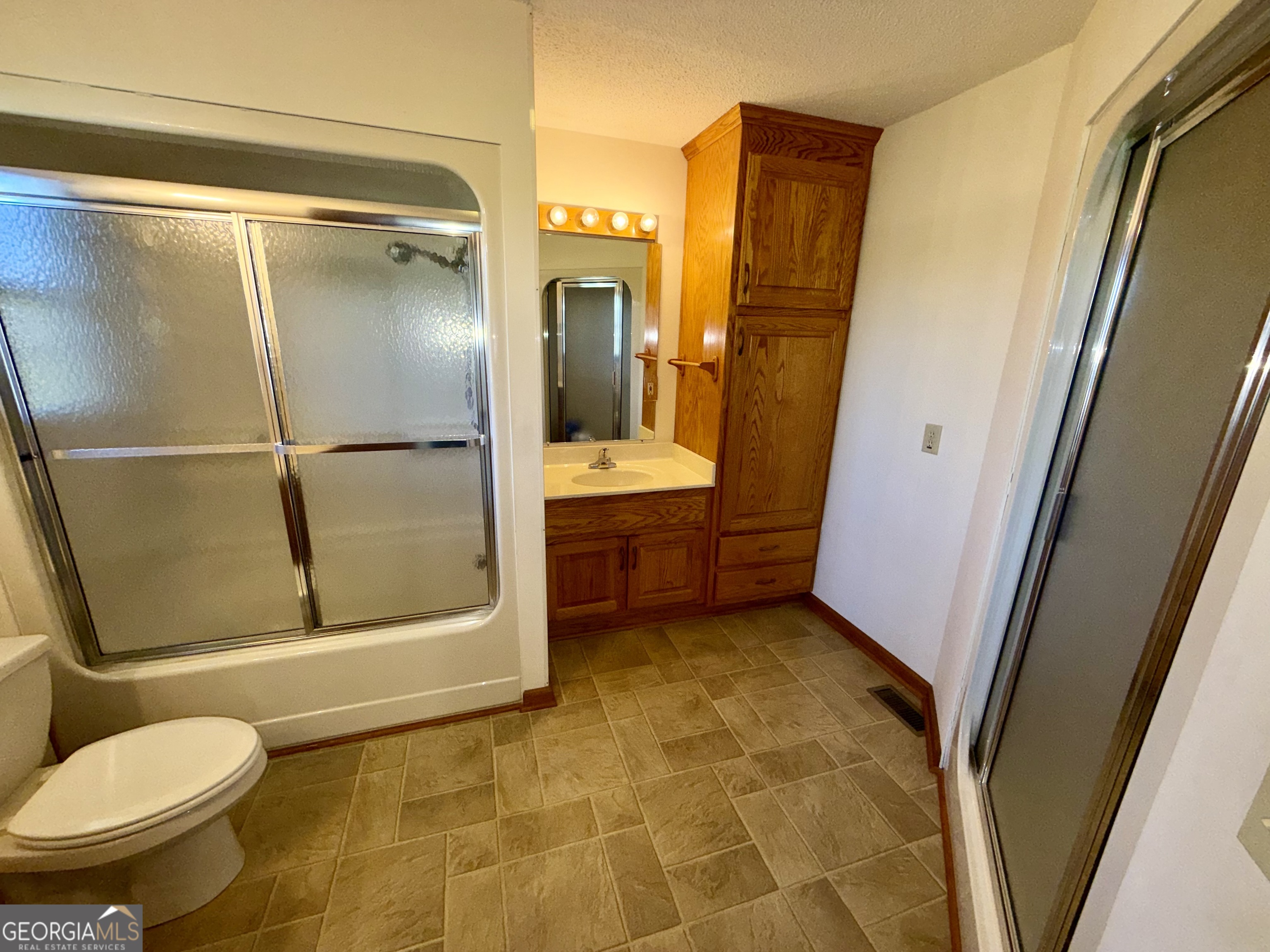 494 Broad Street Bowman, GA 30624 - Photo 32 of 65 a bathroom with a granite countertop shower and a toilet