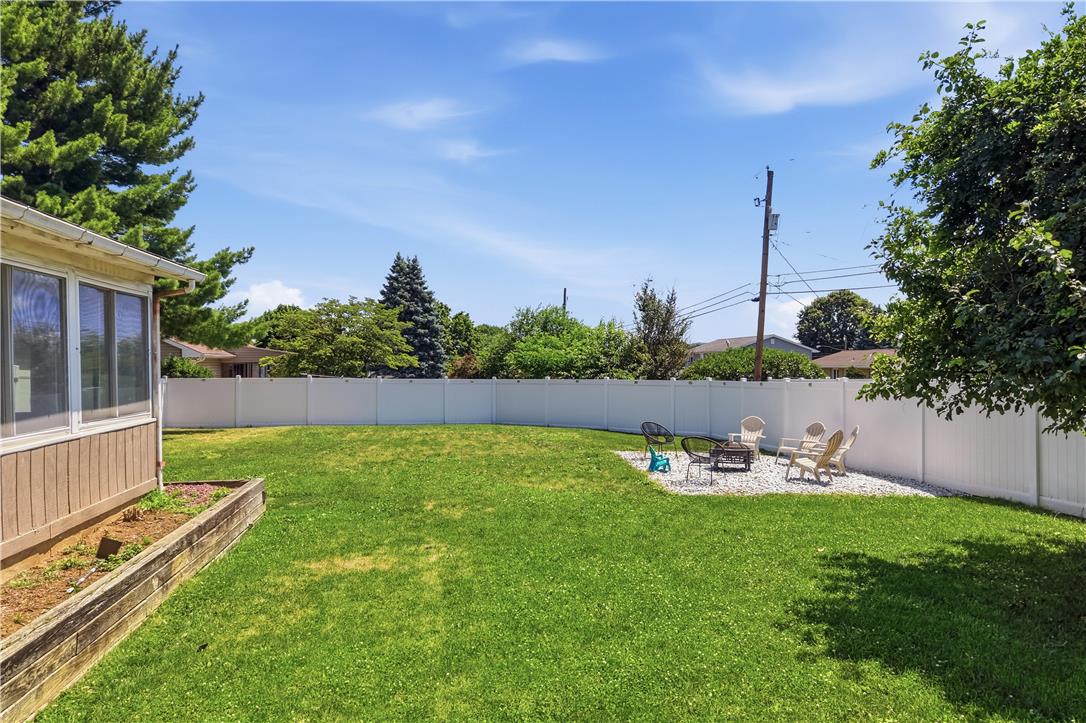 2918 Keystone Street Bethlehem, PA 18020 - Photo 35 of 54 A spacious, enclosed backyard features a verdant lawn and a charming rock-filled fire pit area.