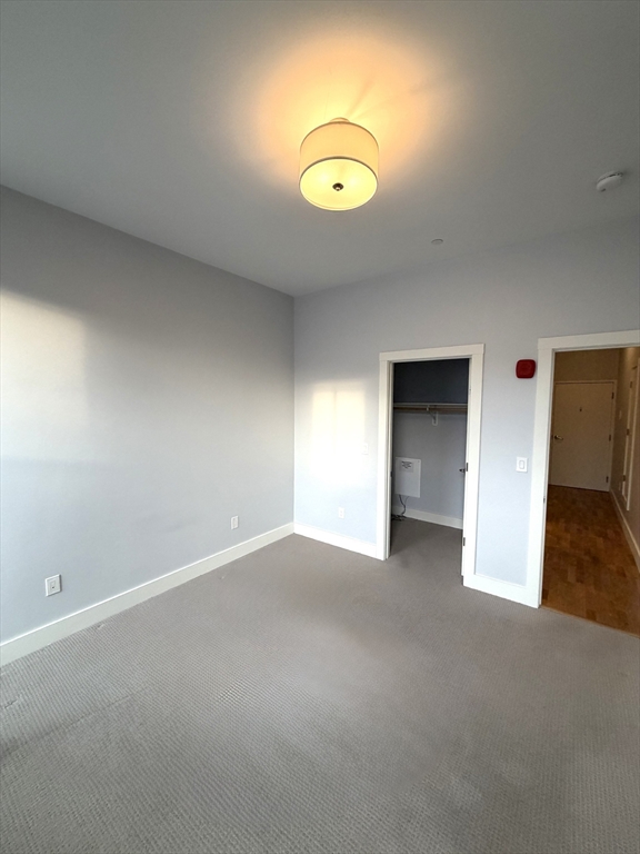 13 West Central Street, Unit 2 Natick, MA 01760 - Photo 5 of 14 an empty room with wooden floor and windows