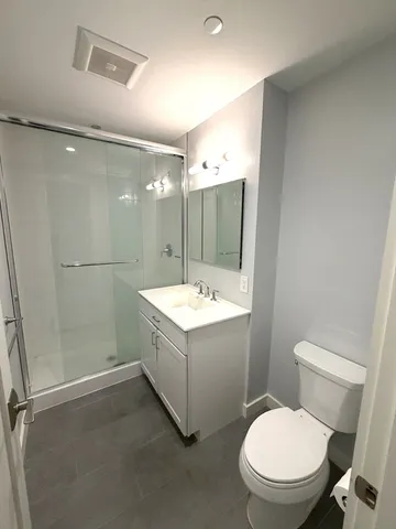 a bathroom with a sink mirror vanity and toilet