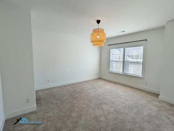 an empty room with a window and wooden floor