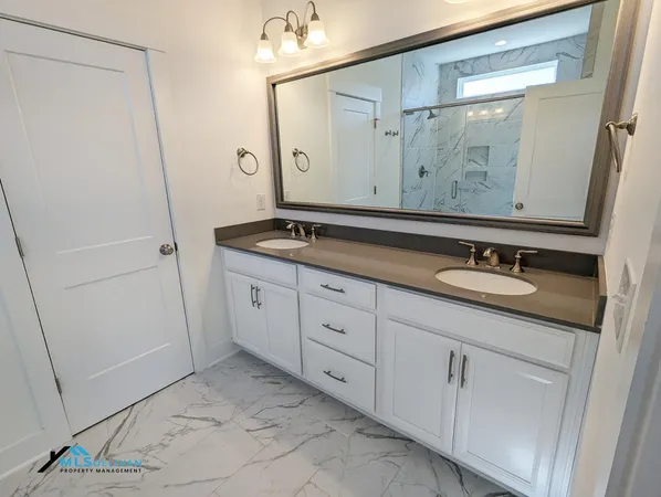a bathroom with a granite countertop sink and a mirror