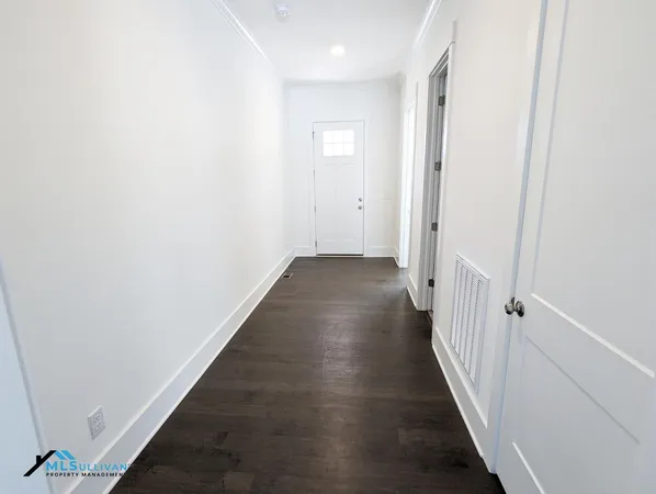 a view of a hallway with wooden floor