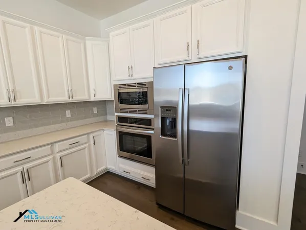 a kitchen with white cabinets and stainless steel appliances