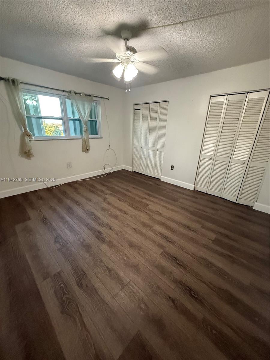 1085 West 68th Street, Unit 309 Hialeah, FL 33014 - Photo 4 of 9 an empty room with wooden floor and windows