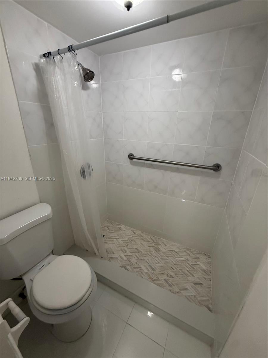 1085 West 68th Street, Unit 309 Hialeah, FL 33014 - Photo 7 of 9 a bathroom with a toilet and a shower