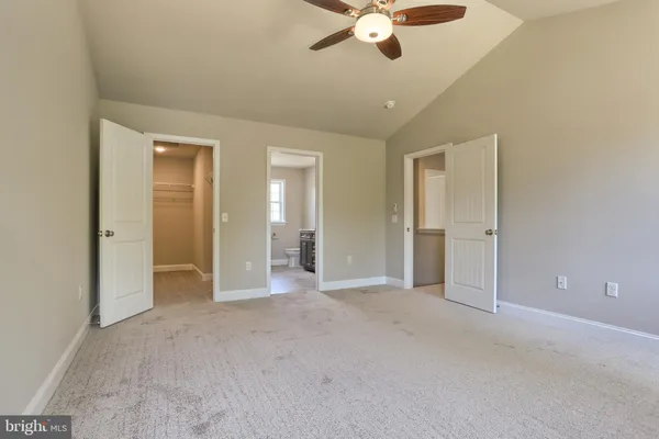 an empty room with fan and entrance