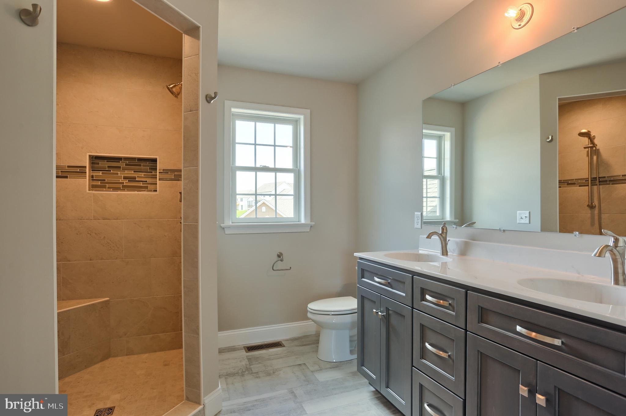 1 Rolling Meadow Road Lebanon, PA 17046 - Photo 17 of 21 a bathroom with a granite countertop sink a toilet a mirror and shower