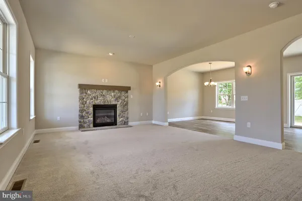 an empty room with windows and fireplace