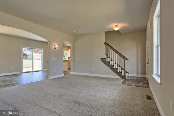 a view of an empty room with wooden floor and windows