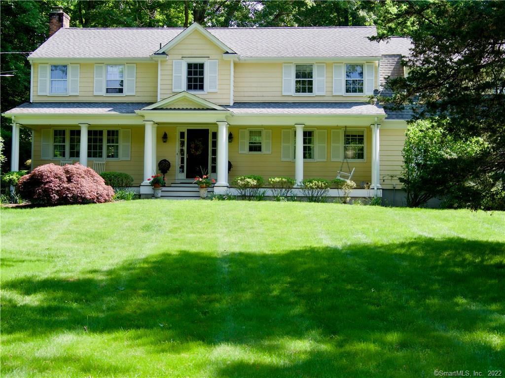 a front view of a house with yard and green space