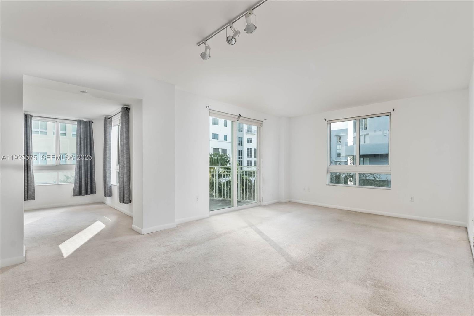 7355 Southwest 89th Street, Unit 502N Miami, FL 33156 - Photo 1 of 14 a view of a big room with windows and chandelier fan