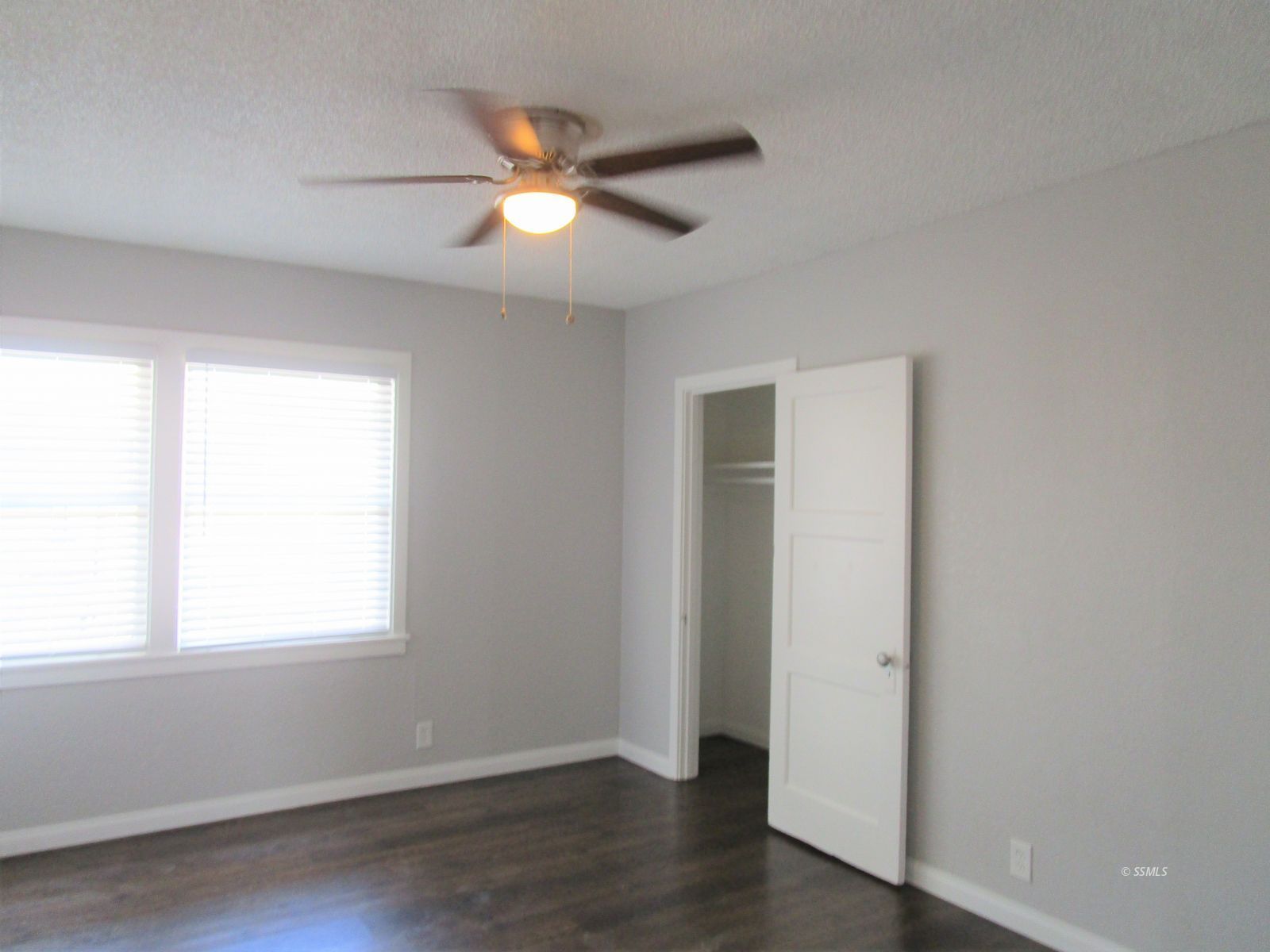 429 South Richmond Road Ridgecrest, CA 93555 - Photo 8 of 10 an empty room with wooden floor fan and windows