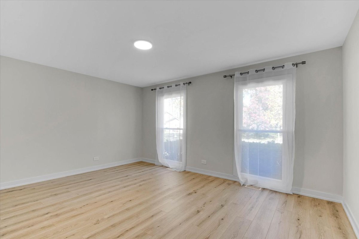 6705 Breckenridge Road Lisle, IL 60532 - Photo 9 of 41 an empty room with wooden floor and windows