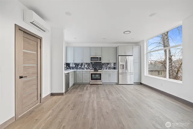 a kitchen with white cabinets and wooden floor