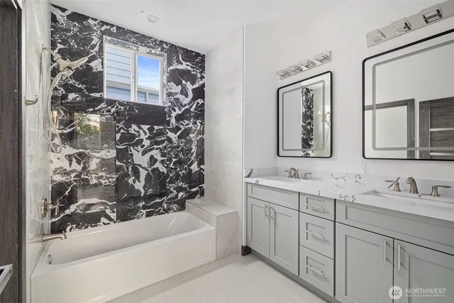 a bathroom with a bathtub sink vanity and mirror