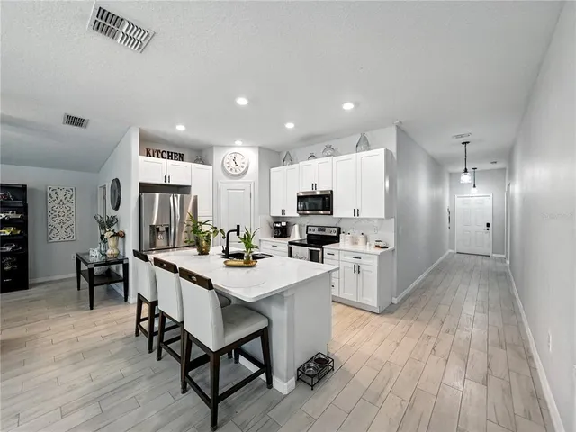 a kitchen with white cabinets and stainless steel appliances